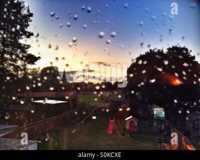 Guardando fuori attraverso un vetro ricoperto di gocce di pioggia. Foto Stock