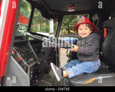 Bimbo di 2 anni si siede in una scala a carrello a open house, Wayland Vigili del Fuoco in Wayland, Massachusetts. Foto Stock