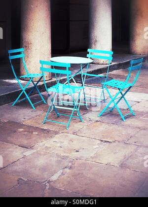 Cafe tavolo e quattro sedie da colonne in pietra. Foto Stock