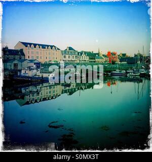 Porto di Stornoway con la Luna Piena al tramonto Foto Stock