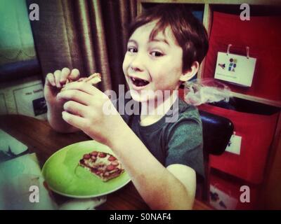 Ragazzo giovane mangiare toast. Foto Stock