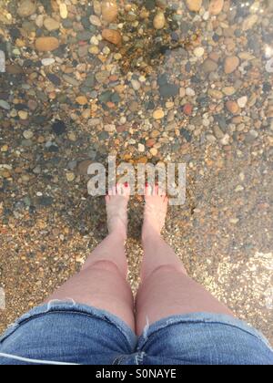 Guardando al mio dipinto toenails nel profondo del Lago Huron sulla mia famiglia della proprietà. Pietre multicolore. Foto Stock