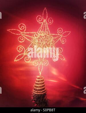 Oro metallizzato star ornamento sulla cima di un albero di Natale. Foto Stock