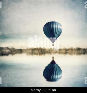 La riflessione di una mongolfiera nel lago Foto Stock