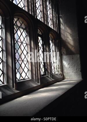 Luce che risplende in attraverso un diamante riquadri Tudor-ser finestra. Foto Stock