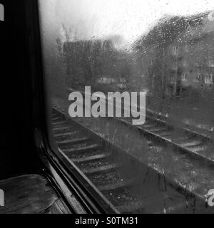 Vista attraverso un treno di umido vetro in bianco e nero Foto Stock