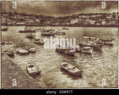Una varietà di piccole imbarcazioni in St Ives Harbour. Un effetto di antiquariato foto che mostra la vista da Smeaton è Pier attraverso il porto verso la città di St Ives in Cornovaglia, Inghilterra. Foto © COLIN HOSKINS Foto Stock