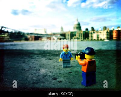 Un paio di Lego persone Scattare foto nella parte anteriore del Millennium Bridge e la Cattedrale di San Paolo al Fiume Tamigi a Londra Foto Stock