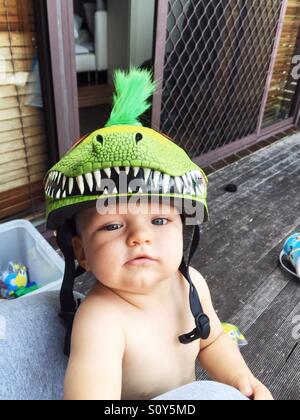 Carino piccolo ragazzo con il suo casco di dinosauri sul Foto Stock