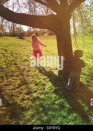 Fratello e Sorella fratelli giocando pieghevole mediante una struttura ad albero in posizione di parcheggio Foto Stock