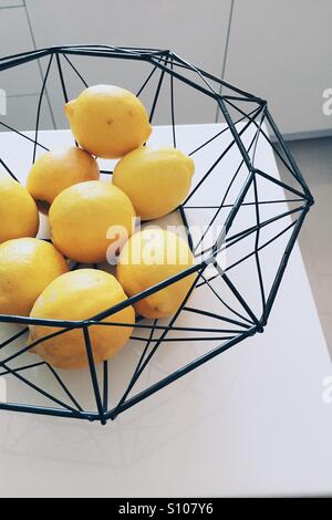 Grappolo di limoni in un cestello di metallo Foto Stock