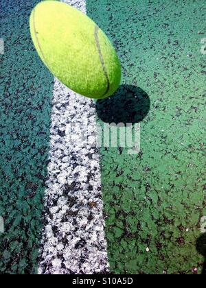 Spostando palla da tennis circa a cadere sulla linea di un campo da tennis Foto Stock