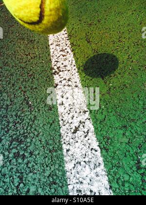 Spostando palla da tennis circa a cadere sulla linea di un campo da tennis Foto Stock