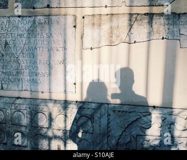 Ombra di una coppia in vacanza a Roma, Italia, con la luce della sera e frammenti di Roma antica in Trastevere. Foto Stock