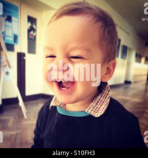 Happy baby boy ridendo, avente un grande tempo nella scuola Foto Stock