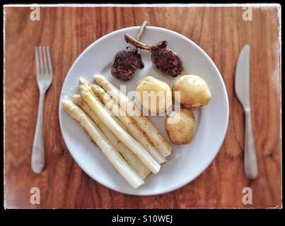 Asparagi bianchi, nuovo raccolto di patate e costolette di agnello Foto Stock