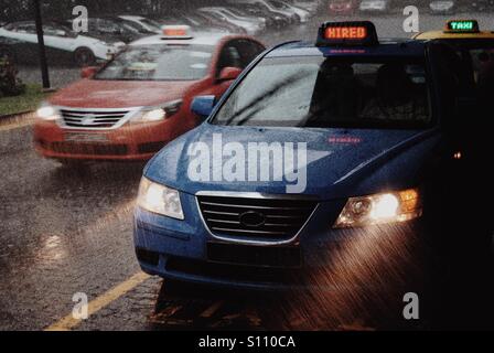 I taxi in corrispondenza di una stazione di sosta dei taxi di piogge torrenziali, Singapore Foto Stock