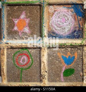 Un bambino di gesso dipinto di una stella a sei punte, il sole, un albero e un fiore decora una strada a Algodonales, Sierra de Cadiz, Spagna Foto Stock