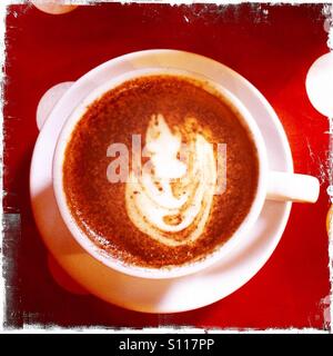 Una tazza di cappuccino dal di sopra su una tovaglia discontinue Foto Stock