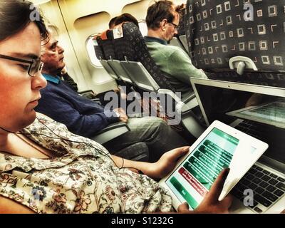 Giovane donna su un volo Easyjet utilizzando un iPad. Utilizzando la DVLA prova teorica per il Regno Unito per i conducenti di auto app. Foto Stock