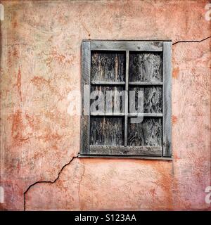Vetro rotto e pareti incrinate sulla parete posteriore di una casa abbandonata sulla riga mormone in Grand Teton National Park, Wyoming USA Foto Stock