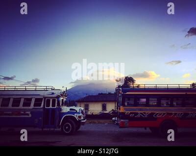 Gli autobus di pollo nella parte anteriore del vulcano Agua al tramonto, Antigua, Guatemala Foto Stock