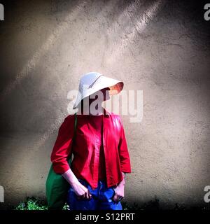 Una donna di medicazione una maglietta rossa e un cappello di paglia pone a Colonia Roma, Città del Messico, Messico Foto Stock