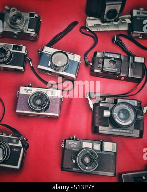Vecchia foto telecamere su un tessuto di colore rosso Foto Stock