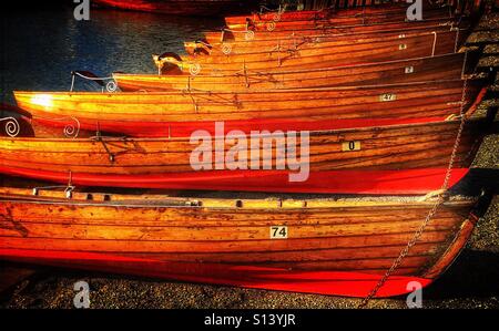 Barche a remi allineate sulla riva del lago a Bowness-on-Windermere Foto Stock