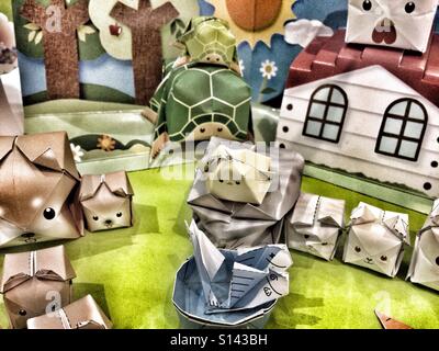 Fatte a mano animali Origami, carta cani, gatti, tartarughe, polli - Cube predisposto alberi Origami, Casa e sullo sfondo Foto Stock