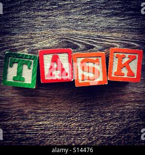 Compito parola scritta con il blocchetto di legno lettera dei giocattoli Foto Stock