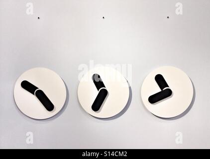 Tre bianco e nero Orologi da parete impostato su sfondo bianco e minimalista, pezzi di tempo e degli arredi interni Foto Stock