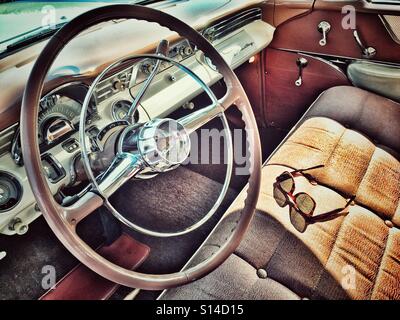 Sole che splende attraverso occhiali da sole getta un' ombra su un classico americano auto sedile unico Foto Stock