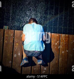 Divertimento estivo in una fontana - 8 anno vecchio ragazzo mettendo la sua testa in una fontana per rinfrescarsi. Foto Stock