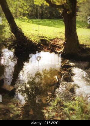 Swing corda su un flusso di luce di autunno Foto Stock