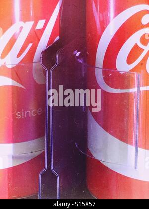 Lattine di coca cola nel distributore Foto Stock