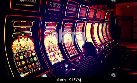 Donna Giocando alle slot machine di Casino Foto Stock