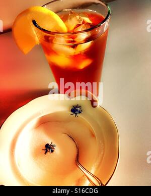 Zuccheriera con houseflies accanto a un bicchiere di tè freddo Foto Stock