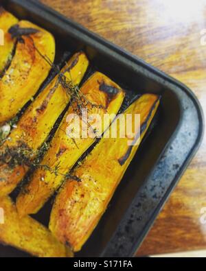 Arrosto di zucca su una tavola di legno sulla superficie di lavoro. Foto Stock