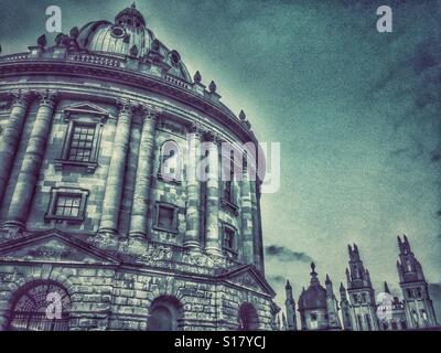 Un HDR vista dell'architettura circolare neoclassico "Radcliffe Camera' edificio e alcuni degli edifici di tutte le anime College. Entrambi gli edifici sono parte dell'Università di Oxford in Inghilterra. © C.HOSKINS. Foto Stock
