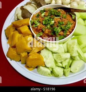 Nam Prik Ongs caratteristiche curry rosso come pure il pomodoro, carne macinata di maiale e coriandolo servita con un impianto di verdure Thai,Chiang Mai provincia nel nord della Thailandia Foto Stock