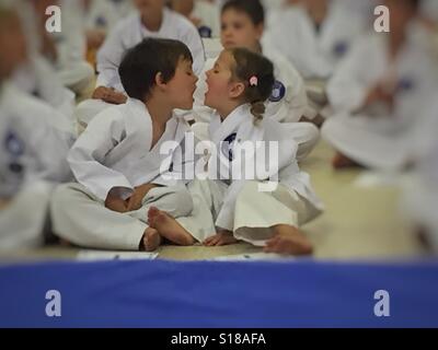 Il Toddler fratelli interagisce con il karate grading Foto Stock