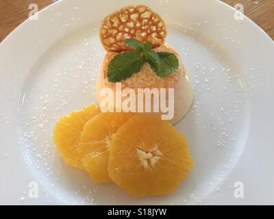 Orange panna cotta con brandy snap e fresche fettine di arancia Foto Stock