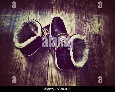 Stivali inverno su un pavimento di legno Foto Stock