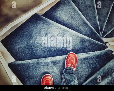 POV percorrendo a piedi una moquette blu scala Foto Stock