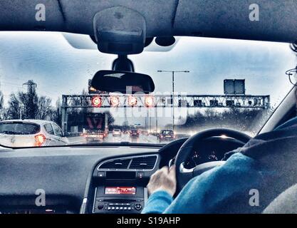 POV guida su una nuova Smart autostrada sotto la pioggia. Il Gantry con limitazioni di velocità sulla M6. Foto Stock