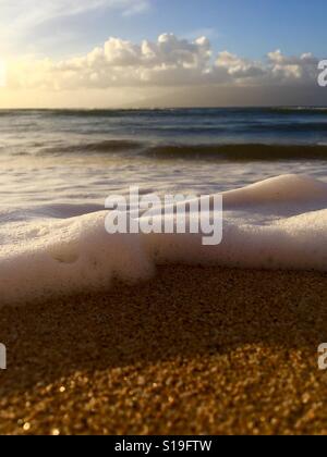 Un rotolamento onde sulla spiaggia al tramonto. Kāʻanapali, Maui, Hawaii. Foto Stock