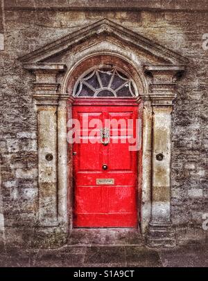 Una luminosa porta rossa fornisce l'ingresso di un elegante casa di città in una grande città in Inghilterra. Credito foto - © COLIN HOSKINS. Foto Stock