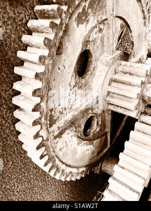 Vecchia ruggine ruota dentata di un verricello in disuso in seppia Foto Stock