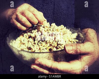 Donna che mantiene una ciotola di popcorn Foto Stock